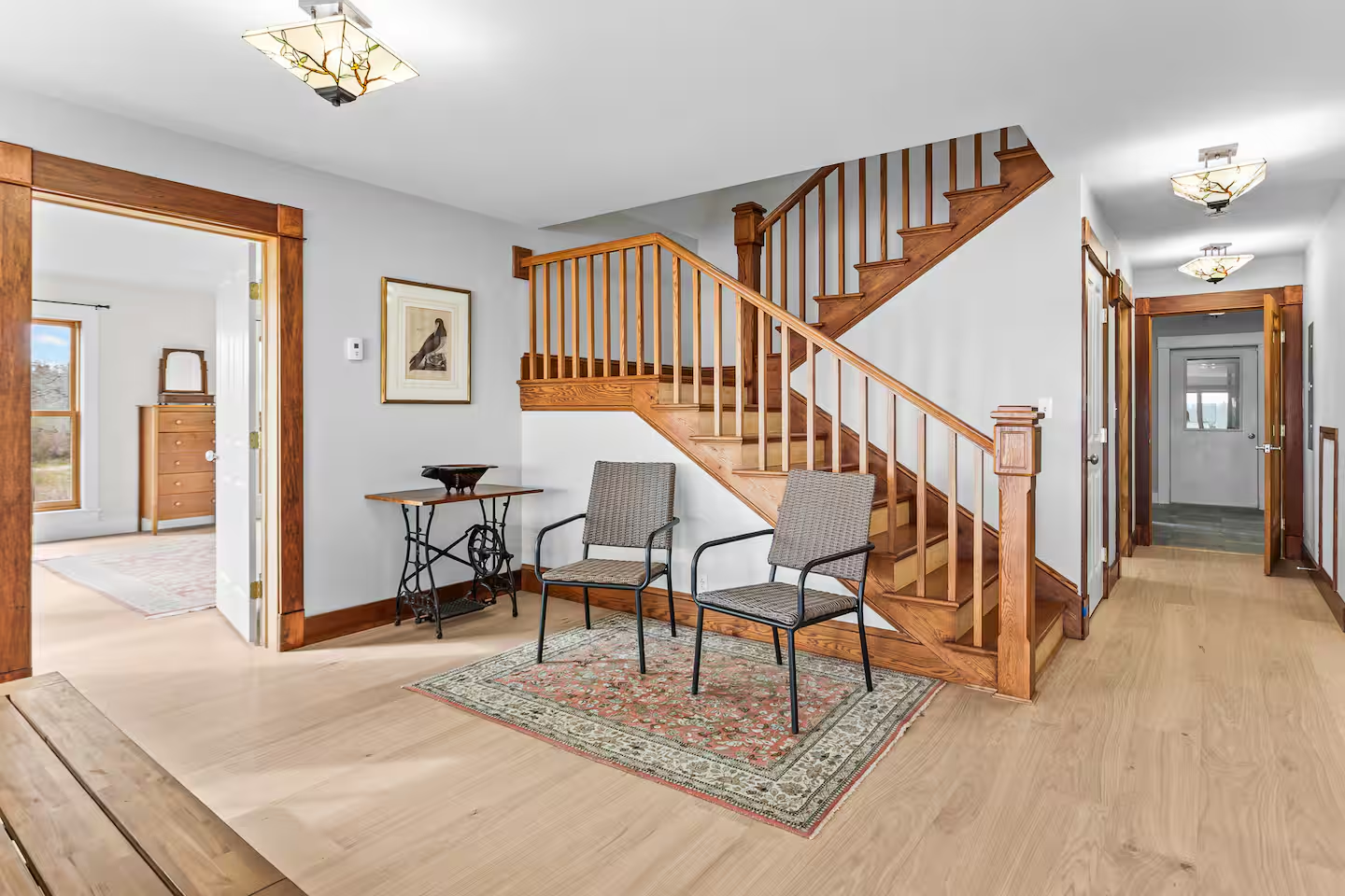 Entryway with oak staircase and wide-plank floors